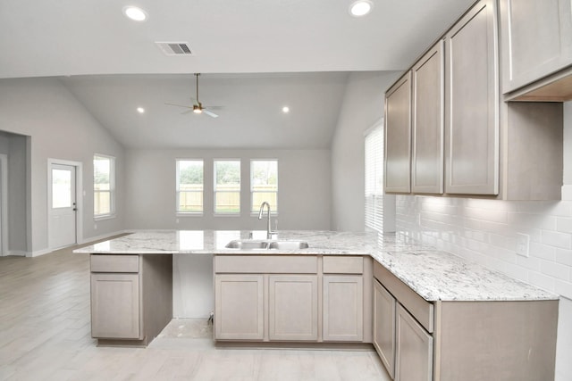 14906 Rural Ridge Rd, Cypress, TX 77429 - kitchen featuring a peninsula, lofted ceiling, ceiling fan, tasteful backsplash, and light stone countertops