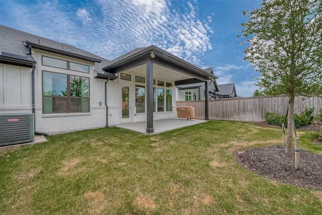 rear view of house with french doors, a yard, a patio, and central AC unit