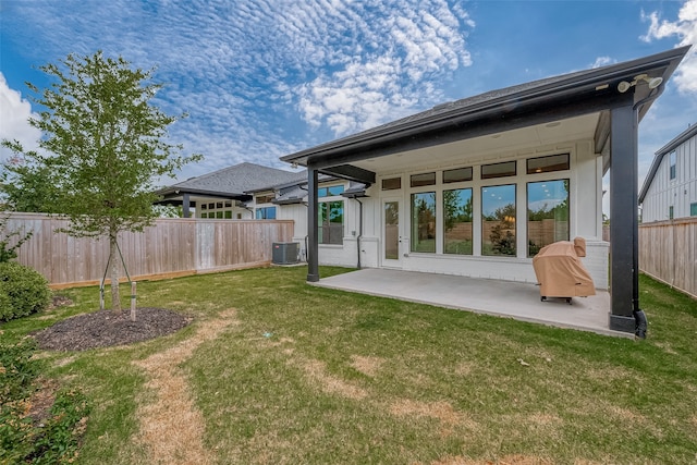 back of property featuring central air condition unit, a lawn, and a patio