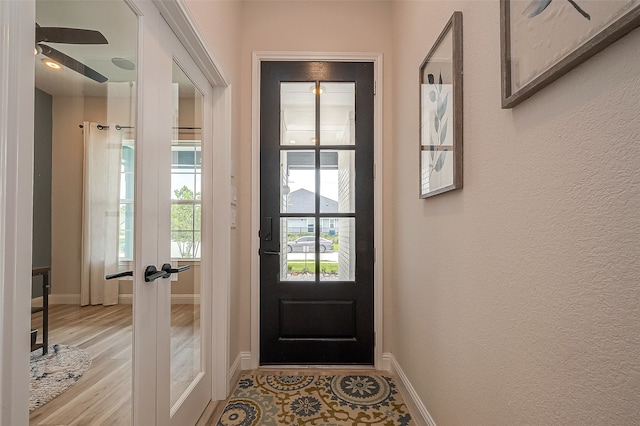 entryway with ceiling fan, light wood-type flooring, and french doors