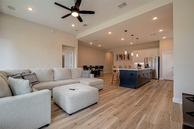 living room with ceiling fan and light hardwood / wood-style flooring