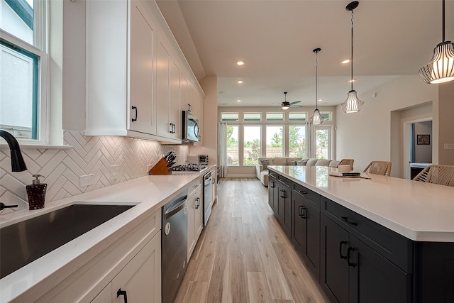 kitchen featuring pendant lighting, white cabinetry, and stainless steel appliances