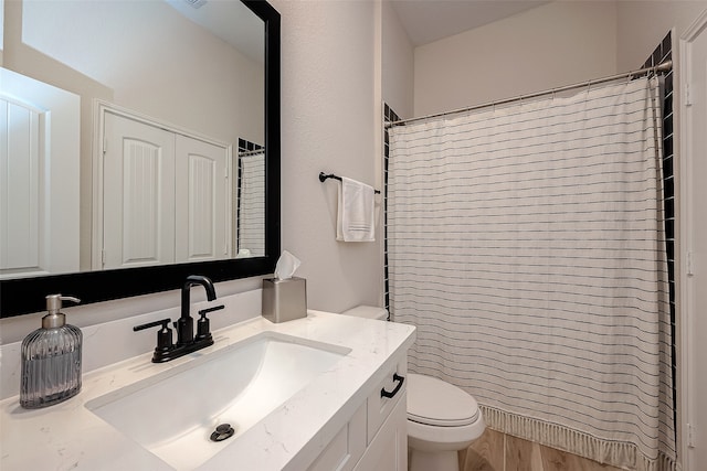 bathroom with a shower with shower curtain, vanity, and toilet