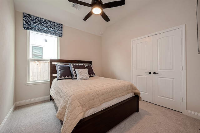 bedroom featuring a closet, light colored carpet, and ceiling fan