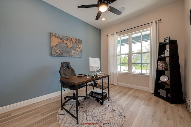 office with light hardwood / wood-style floors and ceiling fan