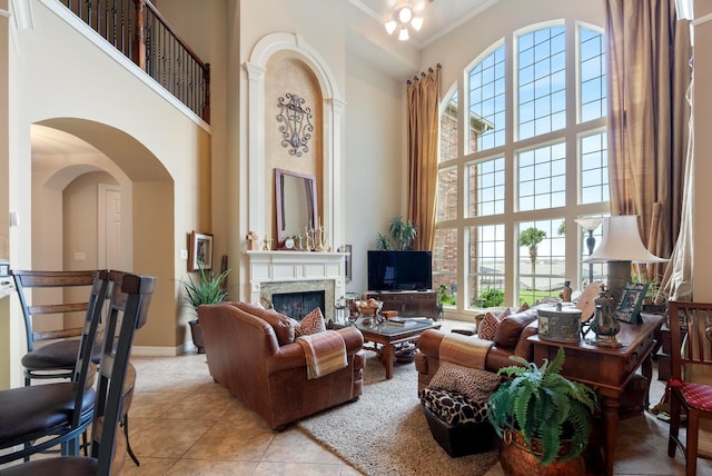 living room featuring a high ceiling, ornamental molding, and light tile patterned flooring