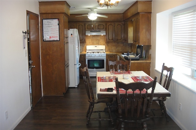 kitchen with dark hardwood / wood-style floors, ceiling fan, white appliances, and backsplash