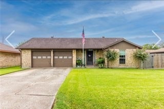 ranch-style home with a front yard and a garage