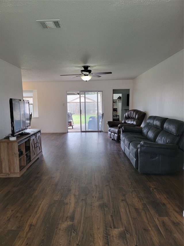 living room featuring a textured ceiling, dark hardwood / wood-style flooring, and ceiling fan