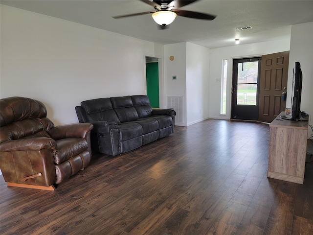 living room featuring ceiling fan and dark wood-type flooring