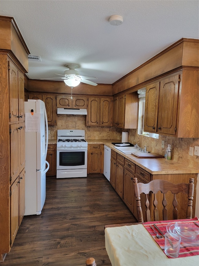 kitchen featuring ceiling fan, dark hardwood / wood-style floors, backsplash, a textured ceiling, and white appliances