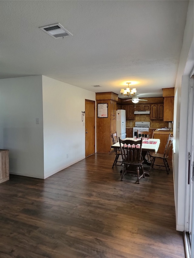 dining area with a textured ceiling, dark hardwood / wood-style flooring, and a notable chandelier