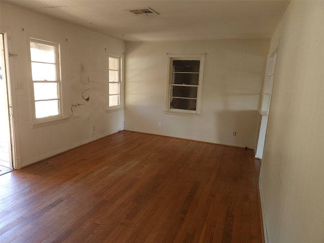 spare room featuring hardwood / wood-style floors and plenty of natural light