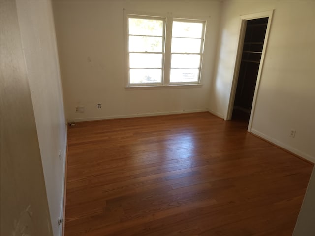 unfurnished room with dark hardwood / wood-style flooring