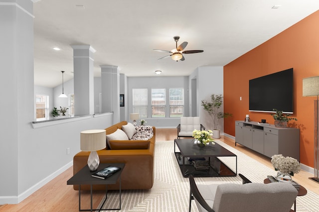 living room with decorative columns, ceiling fan, and light hardwood / wood-style floors