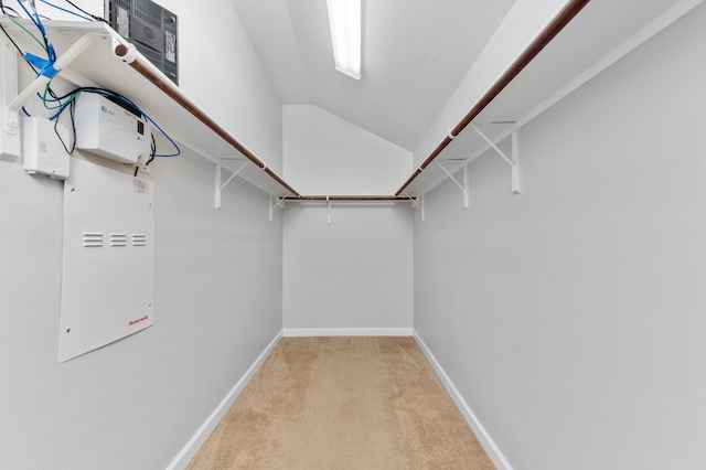 walk in closet featuring light colored carpet and lofted ceiling