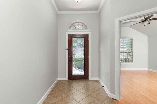 foyer with ceiling fan, ornamental molding, vaulted ceiling, and light wood-type flooring