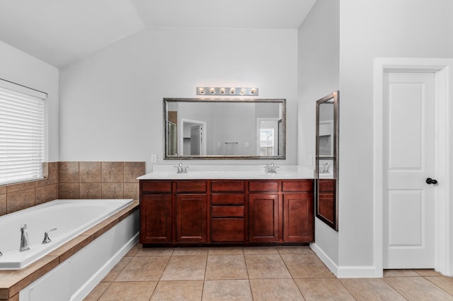 bathroom featuring a tub to relax in, plenty of natural light, lofted ceiling, and tile patterned flooring