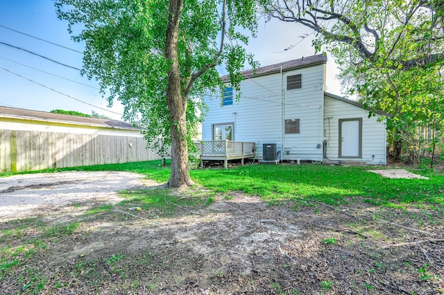 back of house featuring a lawn, central AC, and a deck