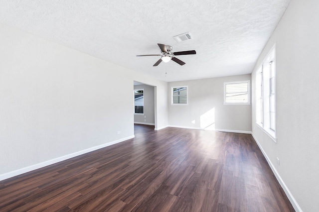 unfurnished room with dark hardwood / wood-style floors, ceiling fan, and a textured ceiling