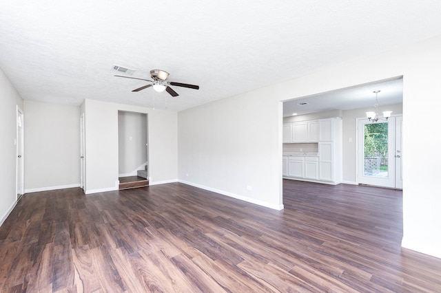 spare room with a textured ceiling, ceiling fan with notable chandelier, and dark hardwood / wood-style floors