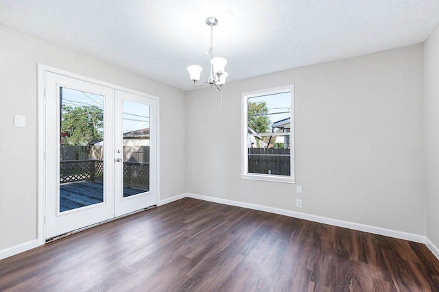 spare room featuring a chandelier, french doors, a textured ceiling, and dark hardwood / wood-style floors