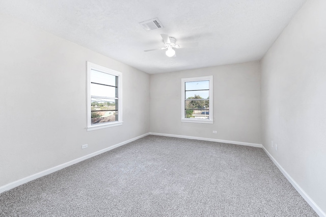 unfurnished room with ceiling fan, carpet, and a textured ceiling