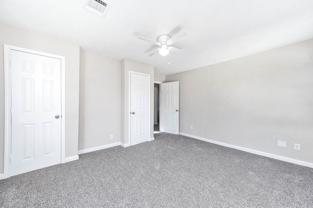 unfurnished bedroom with ceiling fan and dark carpet