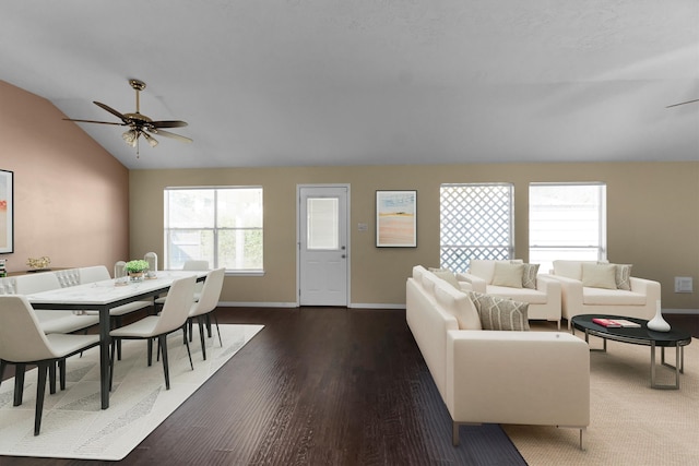 living room with ceiling fan, dark wood-type flooring, and vaulted ceiling