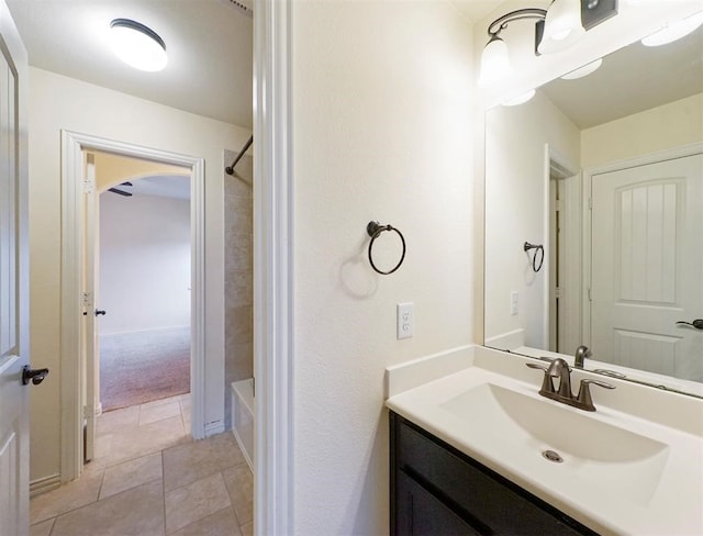 bathroom featuring tile patterned flooring, vanity, and tiled shower / bath