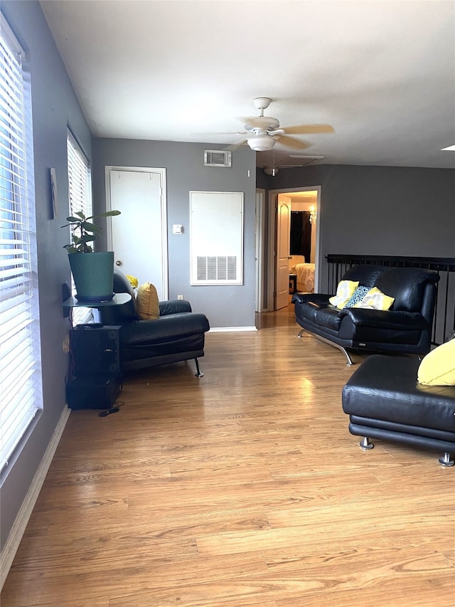 living room featuring ceiling fan and light hardwood / wood-style flooring