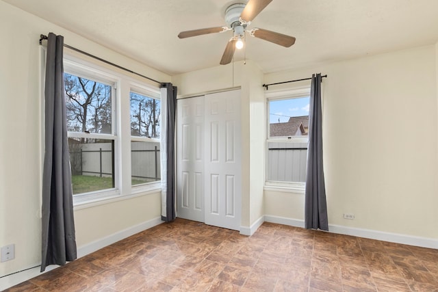 unfurnished bedroom featuring ceiling fan and a closet