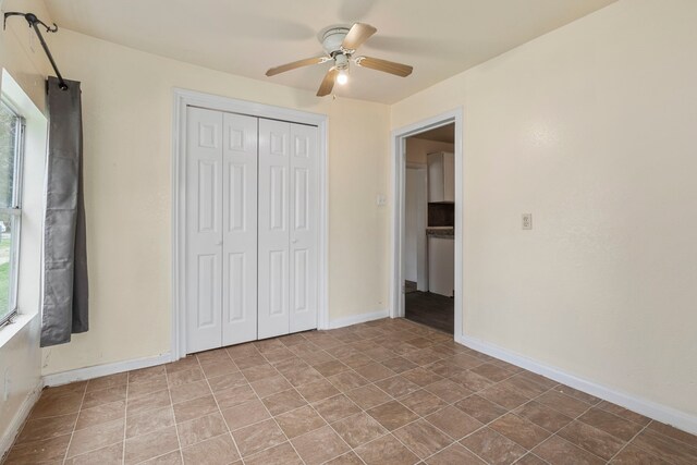 unfurnished bedroom featuring ceiling fan and a closet