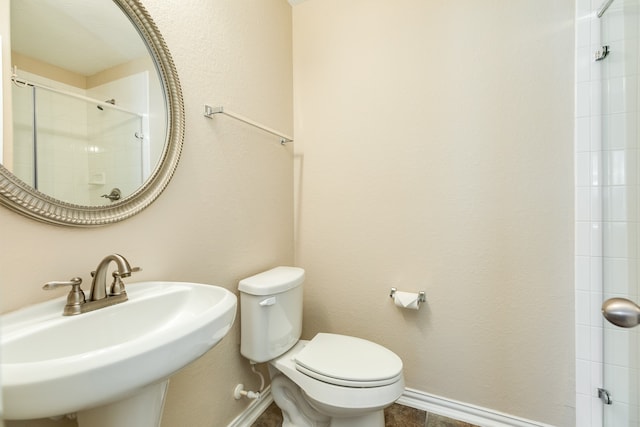 bathroom with sink, an enclosed shower, and toilet