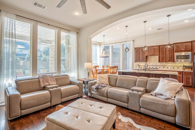 living room with dark hardwood / wood-style floors and ceiling fan