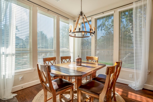 dining area with dark hardwood / wood-style floors and a chandelier