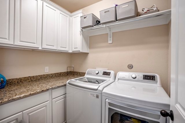 laundry room with cabinets and washer and clothes dryer