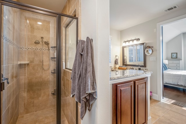 bathroom with tile patterned flooring, vanity, and walk in shower