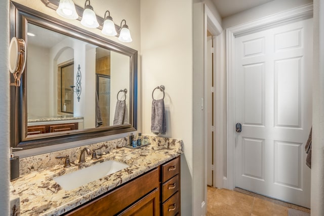 bathroom featuring tile patterned floors, vanity, and a shower