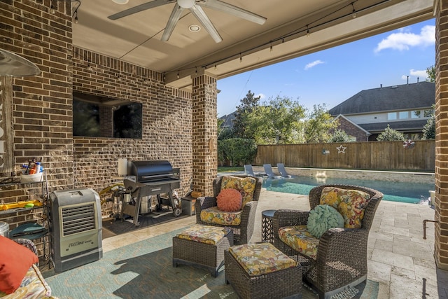 view of patio / terrace featuring area for grilling, pool water feature, heating unit, ceiling fan, and a fenced in pool