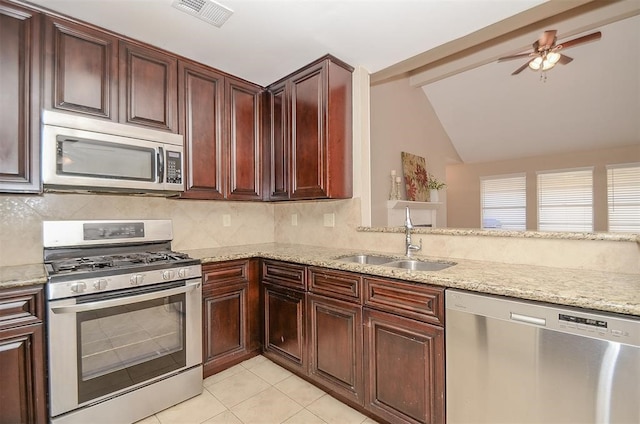 kitchen with lofted ceiling with beams, sink, ceiling fan, appliances with stainless steel finishes, and light stone counters