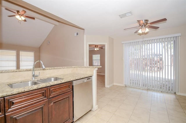 kitchen featuring dishwasher, lofted ceiling, sink, light tile patterned floors, and light stone counters