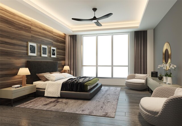 bedroom featuring a ceiling fan, a tray ceiling, and hardwood / wood-style flooring