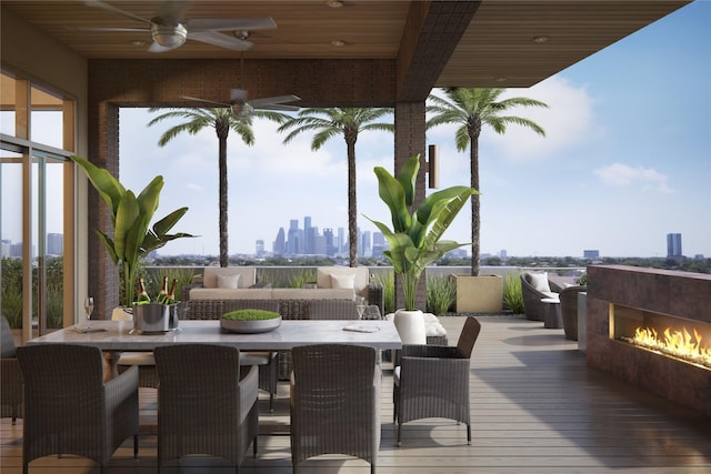 wooden terrace with ceiling fan and an outdoor fireplace