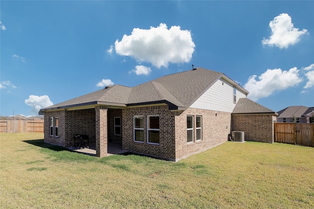 rear view of house with a yard, cooling unit, and a patio area