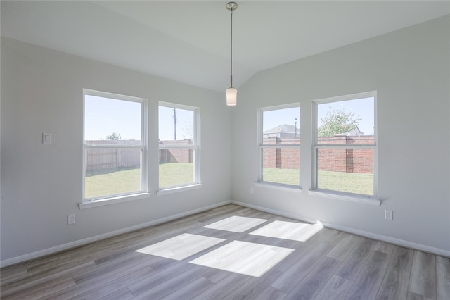 unfurnished dining area featuring light hardwood / wood-style floors and lofted ceiling