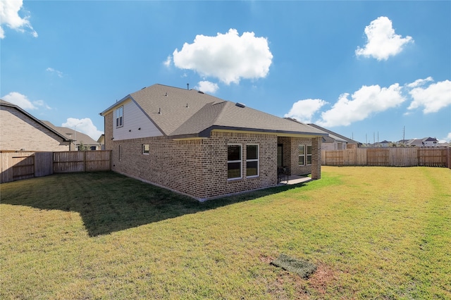 rear view of house featuring a yard