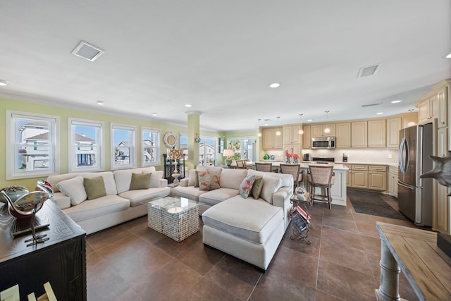 living room featuring dark tile patterned flooring, ornate columns, and crown molding