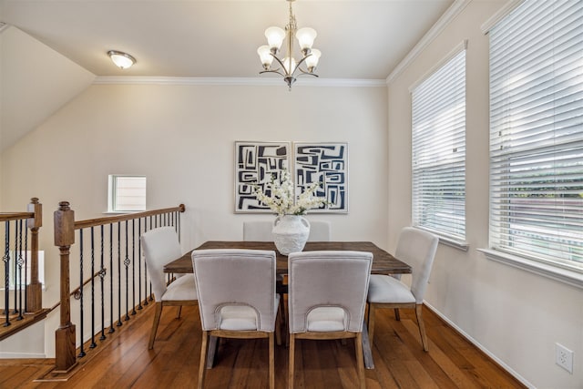 dining room featuring hardwood / wood-style floors, a healthy amount of sunlight, ornamental molding, and an inviting chandelier