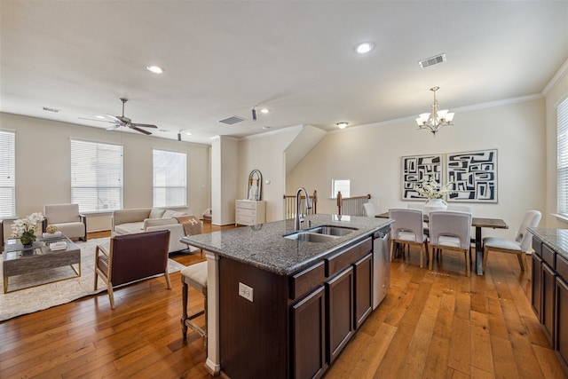 kitchen featuring dishwasher, sink, crown molding, hardwood / wood-style floors, and an island with sink